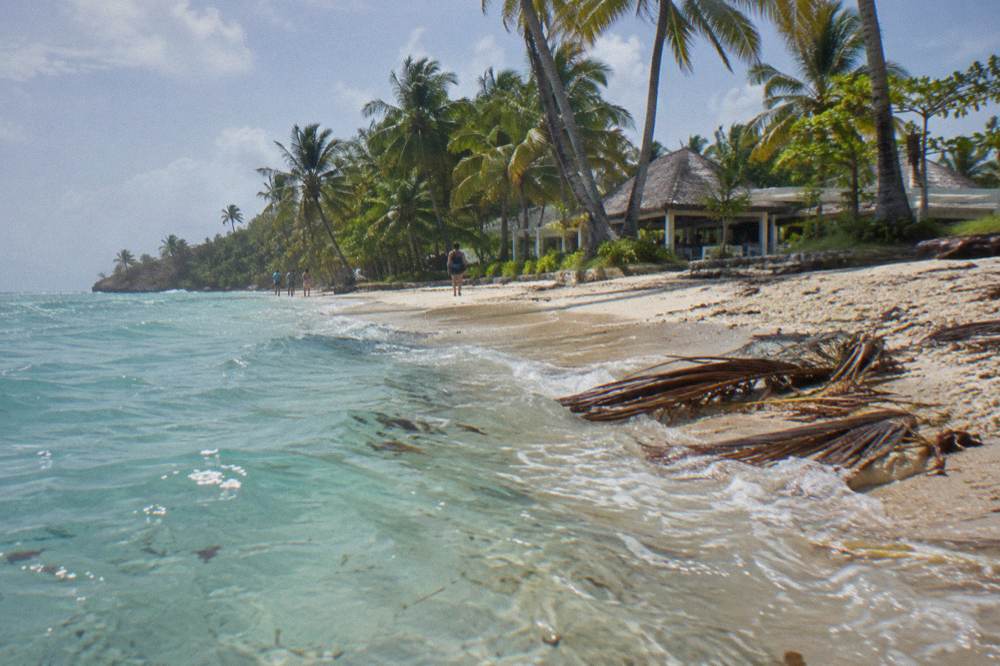 Turquoise shallow water washing onto a small palm fringed sandbar island in Samaná Bay