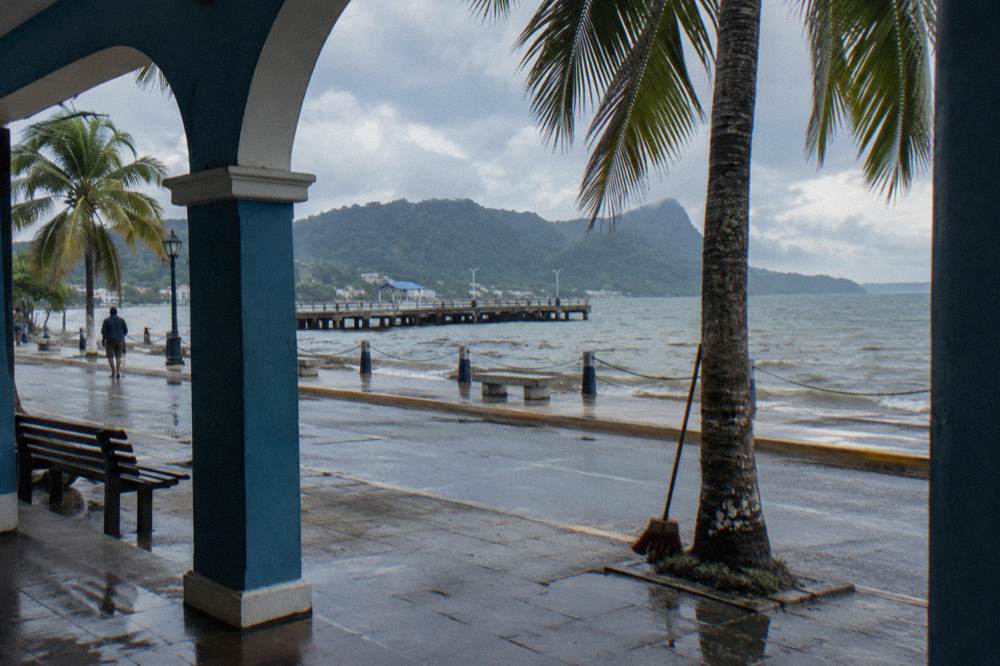 A wide tropical bay under morning light with a coastal town along the shore