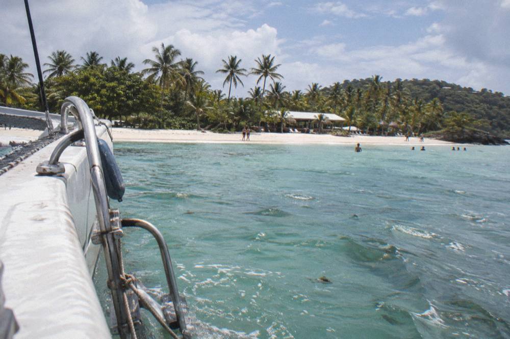 A catamaran approaching the palm-lined shore of Cayo Levantado island