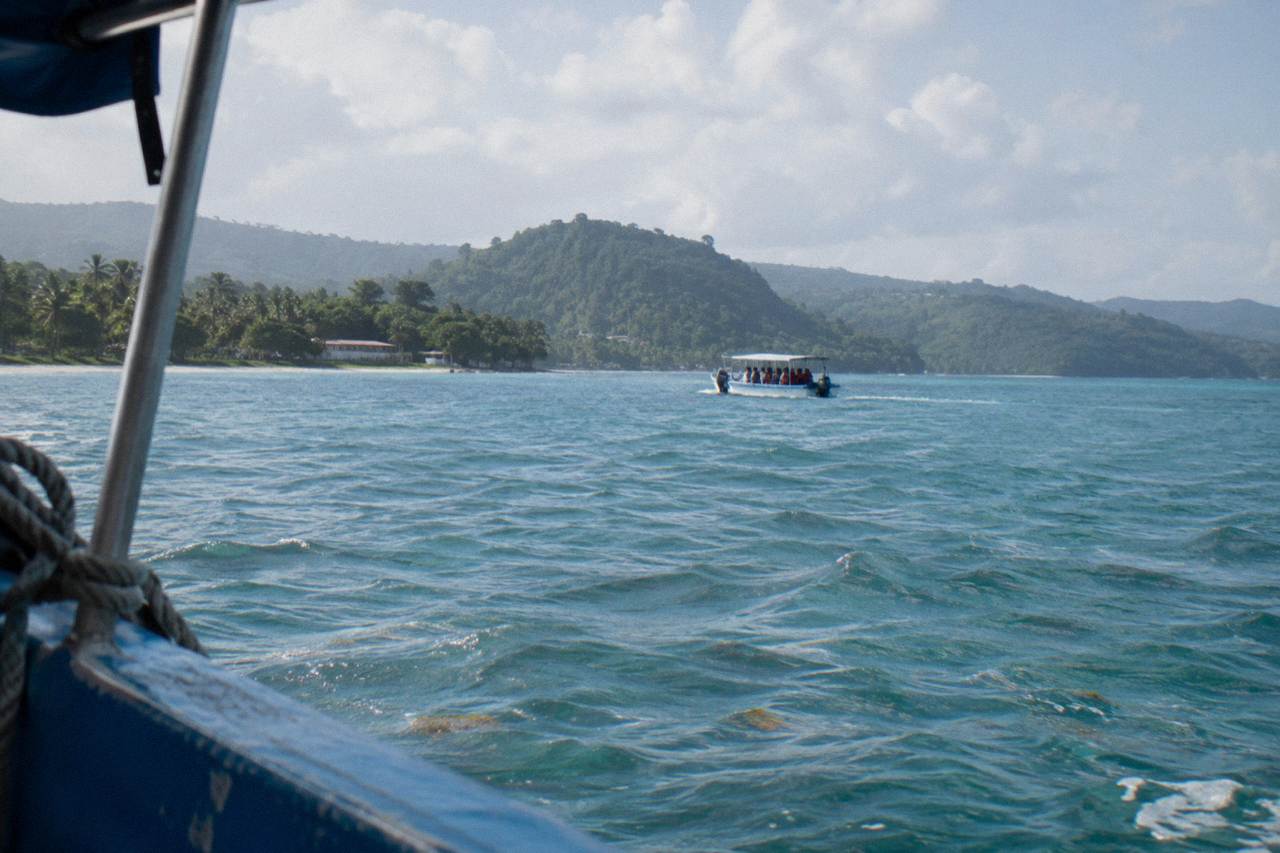 Calm turquoise water of Samana Bay with a small whale watching boat in the distance