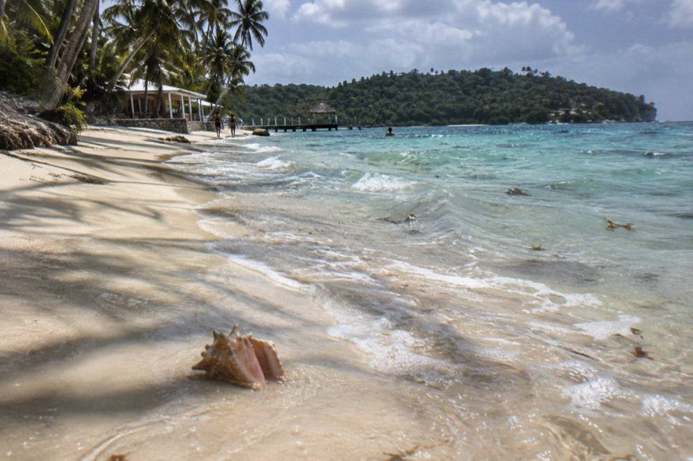 Turquoise shallow water and pale sand along the Cayo Levantado shoreline