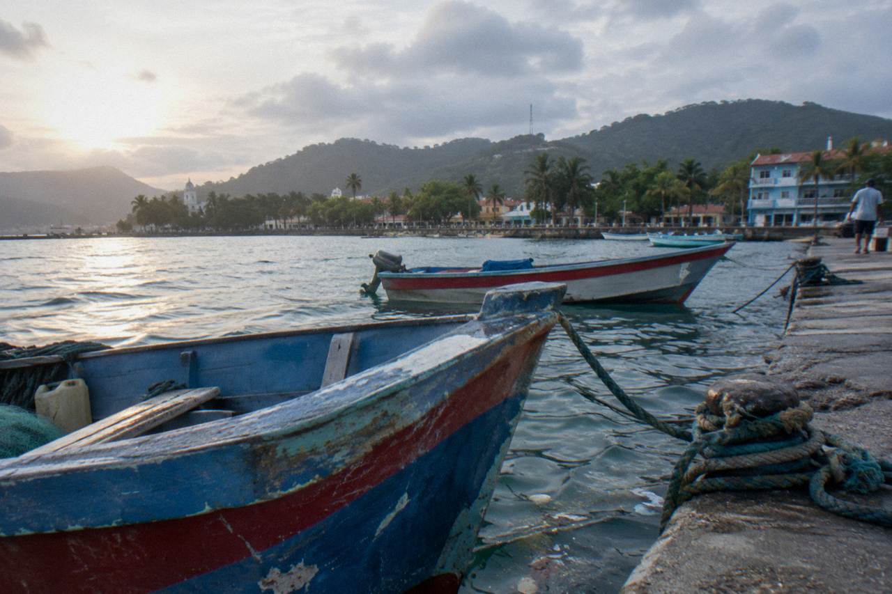 Colorful fishing boats moored along the Samaná waterfront on a calm morning