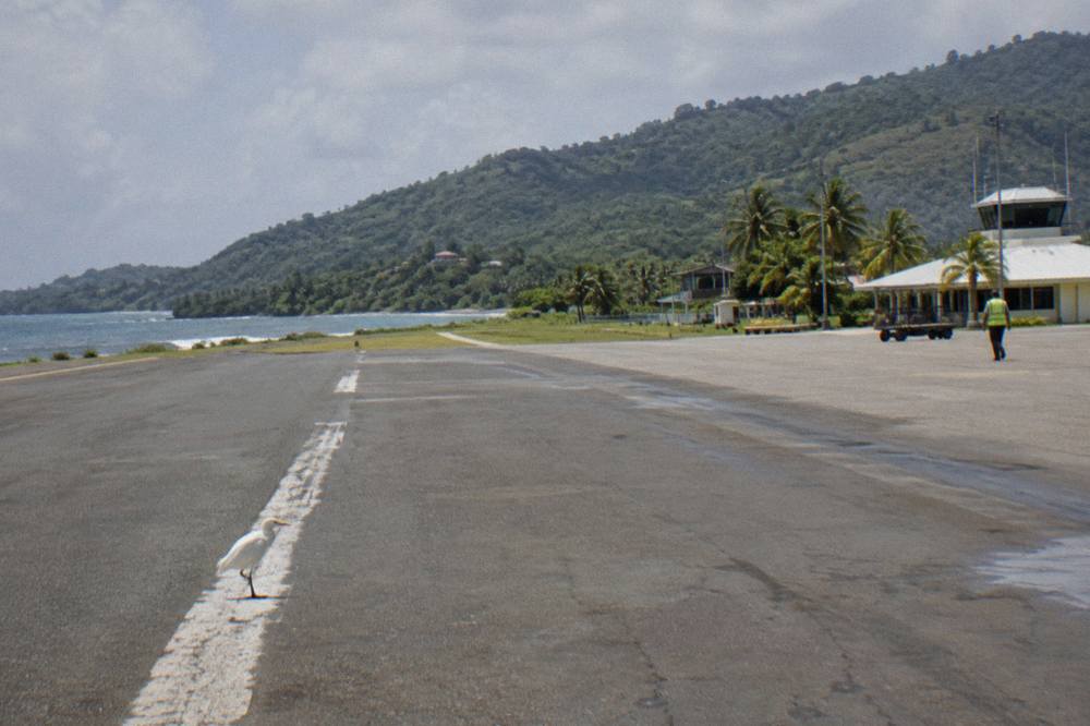 Wide empty highway cutting through green forested hills in the Dominican Republic