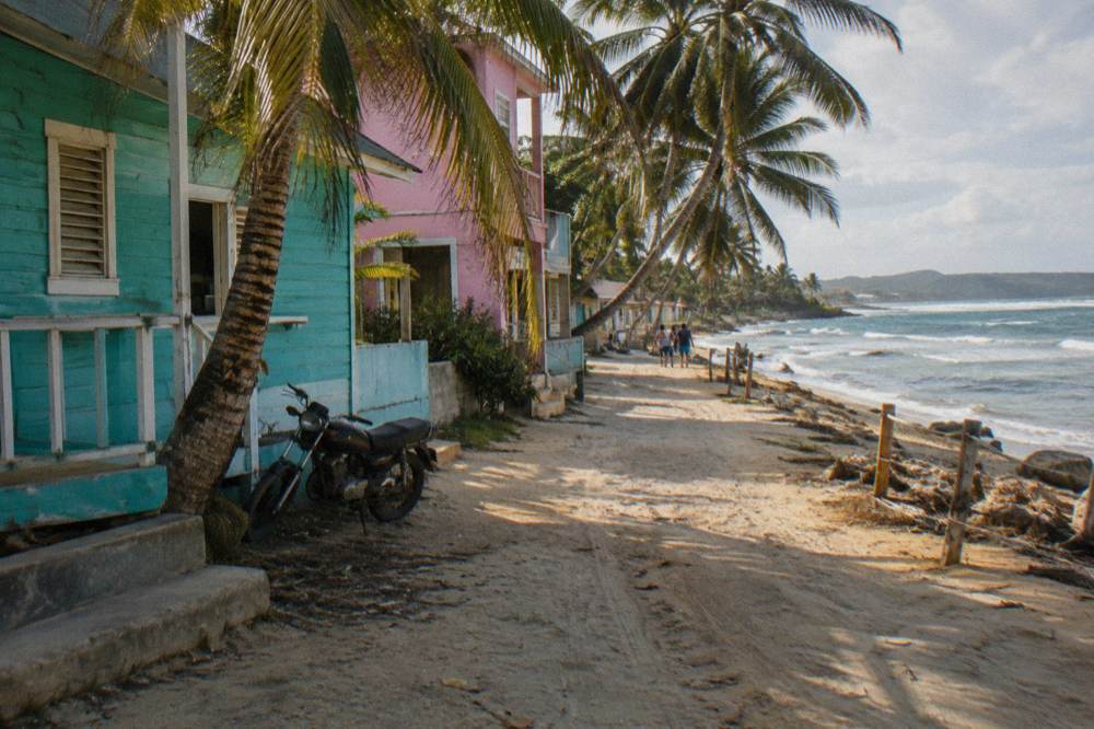 Palm-lined beach town street with colorful buildings in the late afternoon