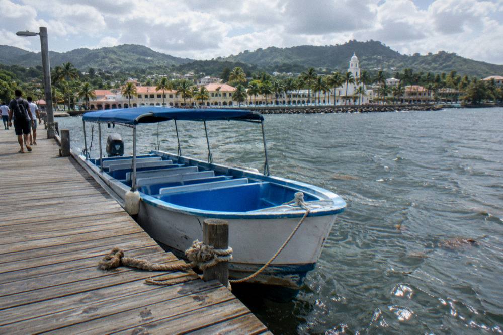Passengers boarding a small tour boat at a wooden dock in the morning