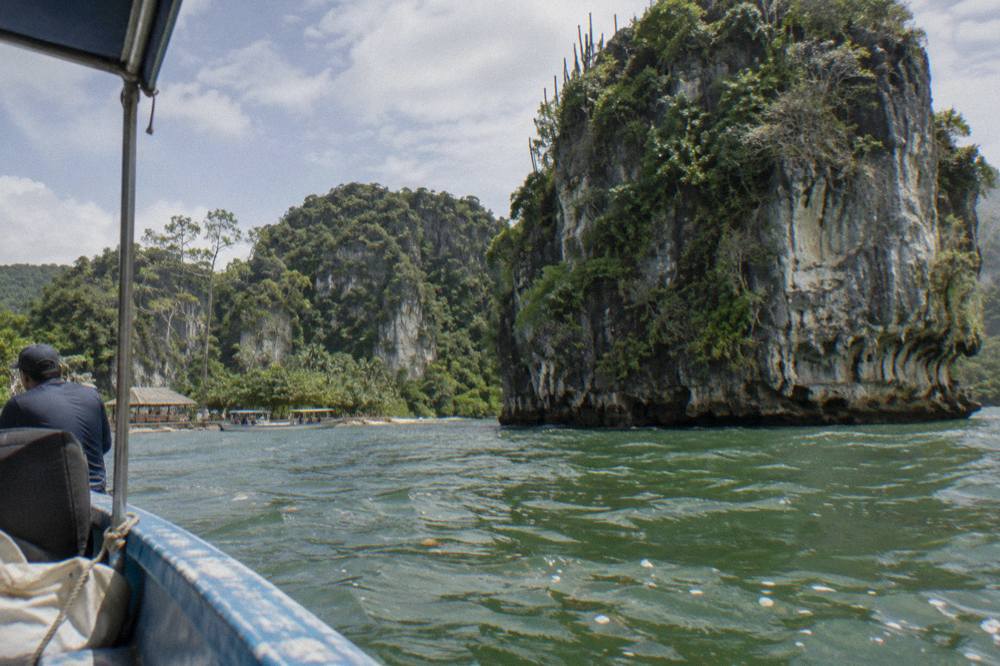 Towering limestone karst formations rising from calm green water inside Los Haitises National Park