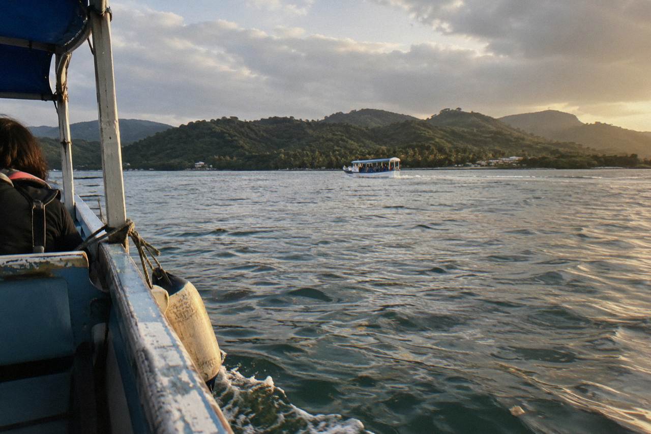 Calm morning water in Samaná Bay with a small whale watching boat in the distance