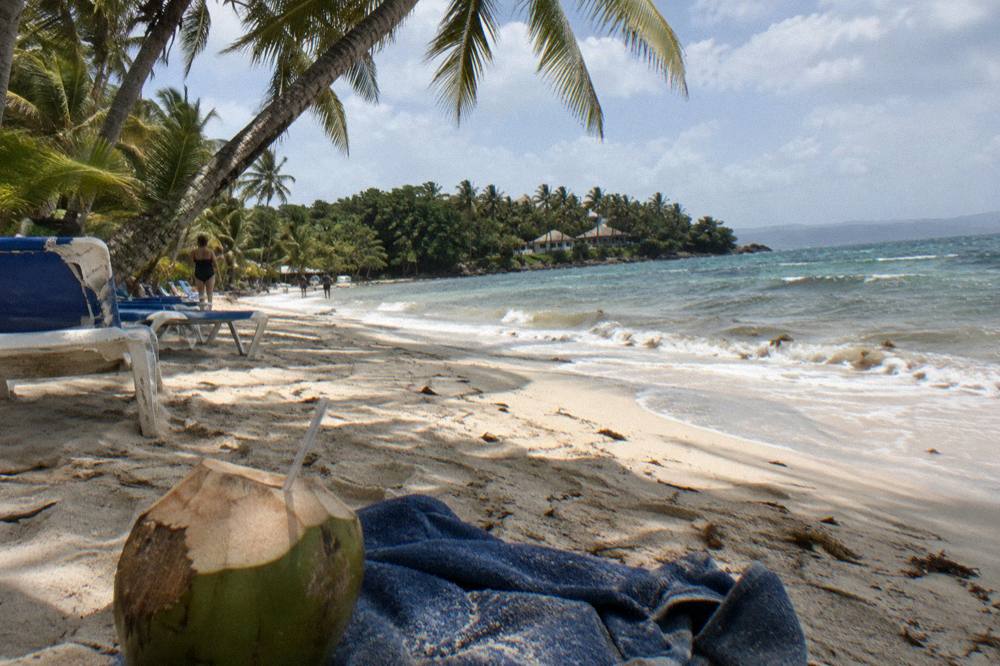 Beach chairs and palm shade on the sand of Cayo Levantado island
