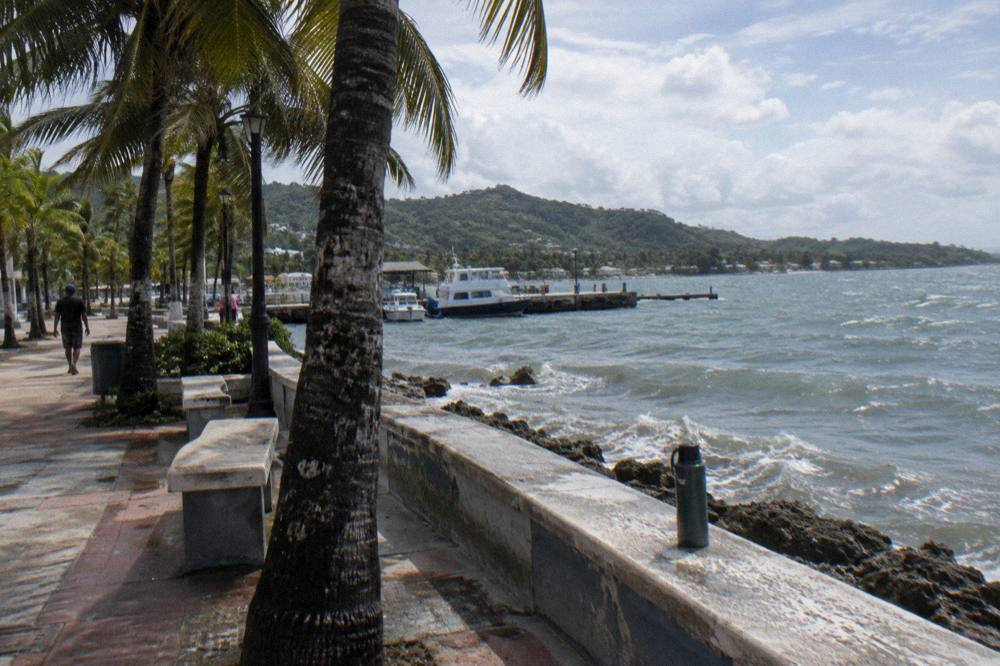 Tour van parked beside the Samana waterfront malecon in morning light