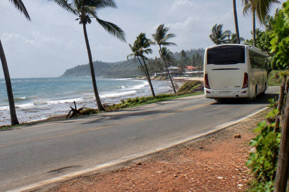 A tour bus on a coastal road heading toward the Samana peninsula