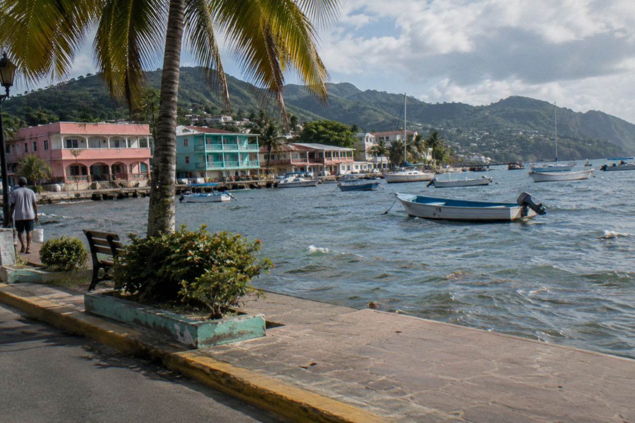 Colorful waterfront buildings along the malecon in Samaná town with boats moored in the bay